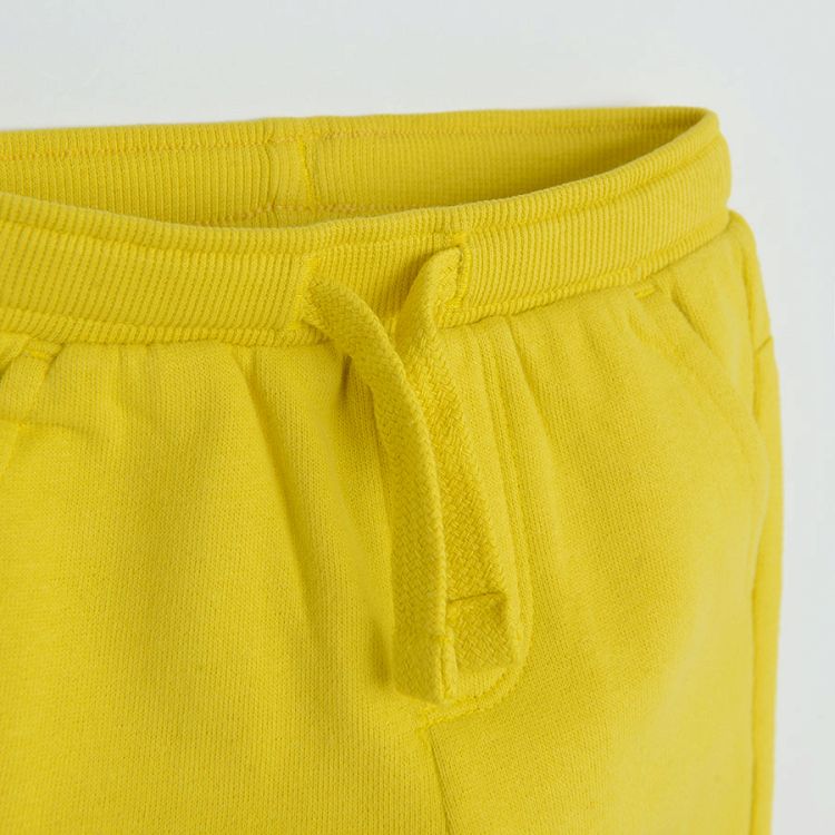 Yellow jogging pants with funny face on knee