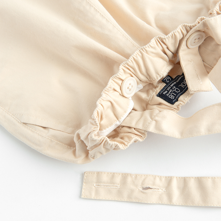 Brown bodysuit with bow tie and ecru pants with suspenders