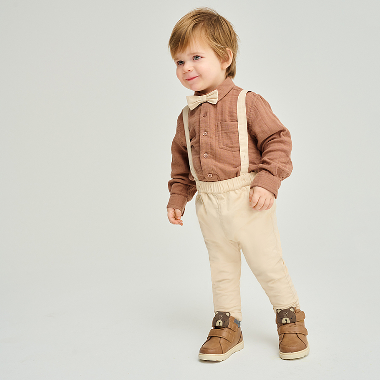 Brown bodysuit with bow tie and ecru pants with suspenders