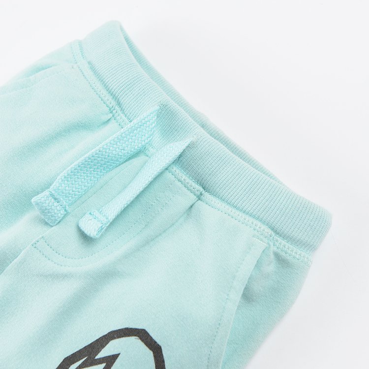 Light mint jogging pants with dinosaur print on the side and adjustable waist