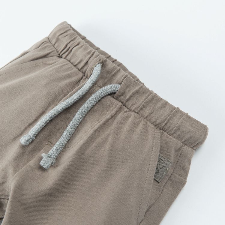 Light borwn jogging pants with lions print on the knees and adjustable waist