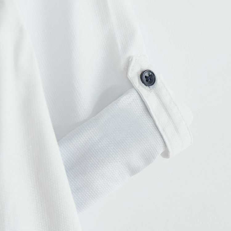 White long sleeve shirt with sleeve rolling up to a button