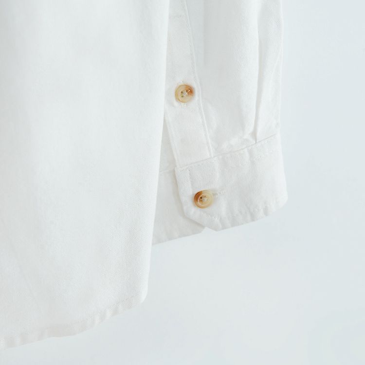 White long sleeve shirt with sleeve rolling up to a button