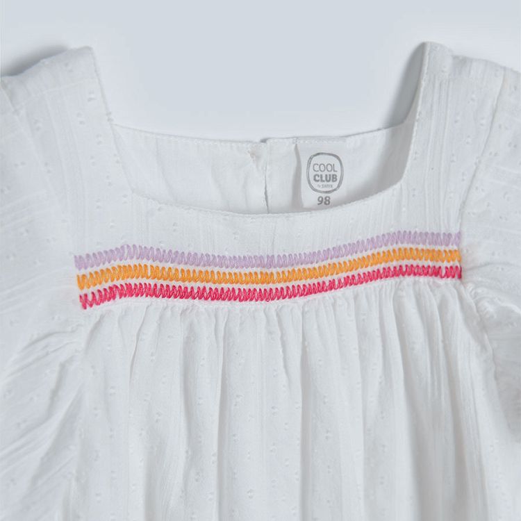 White sleeveless blouse with square embrodered neckline and ruffles on the shoulders
