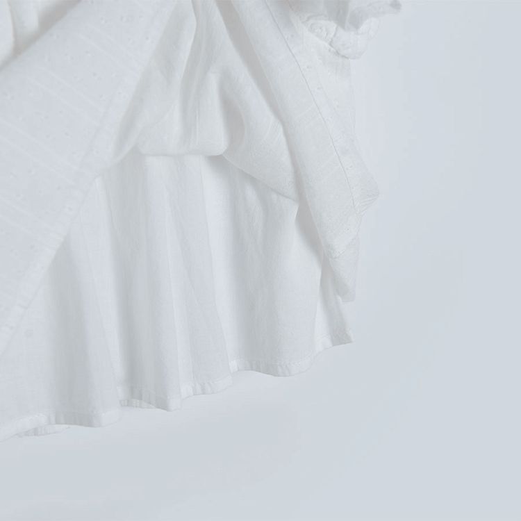 White sleeveless blouse with square embrodered neckline and ruffles on the shoulders