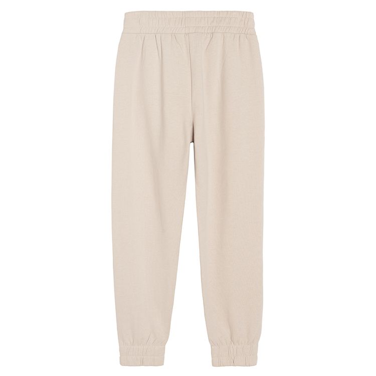 Beige jogging pants with elastic band around the waist and ankles
