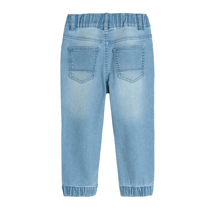 Light blue denim trousers with cord  and elastic band around the ankles
