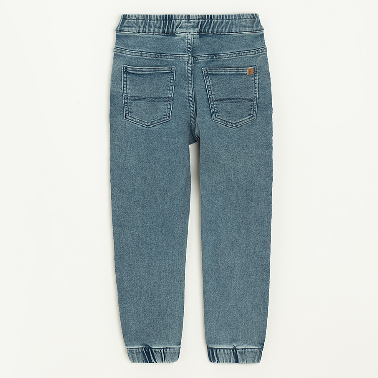Blue denim pants with cord and elastic around the ankles