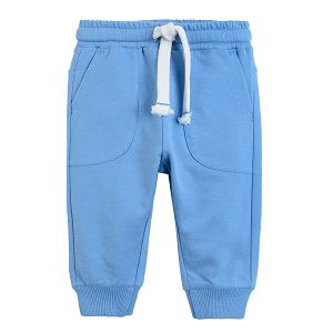 Blue jogging pants with adjustable waist elastic band around the ankles and pockets