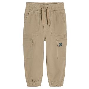 Beige trousers with outside pockets and adjustable waist