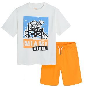 White short sleeve T-shirt with tropical print and orange shorts with adjustable waist and pockets