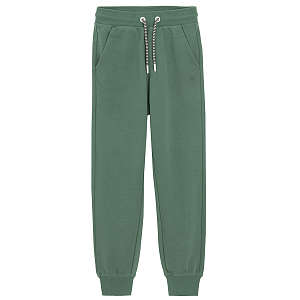 Green sweatpants with elastic around ankles and cord