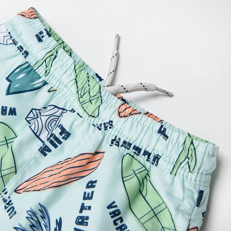 Blue swimming shorts with tropical print and UV+50