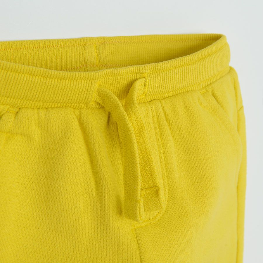Yellow jogging pants with funny face on knee
