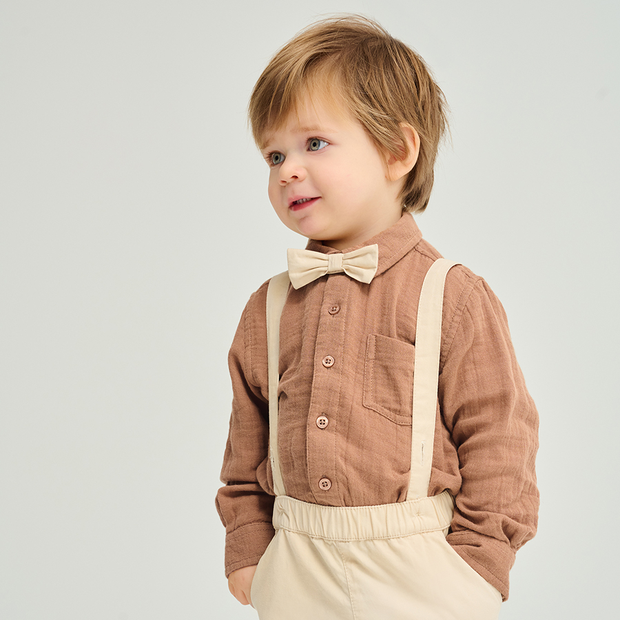 Brown bodysuit with bow tie and ecru pants with suspenders