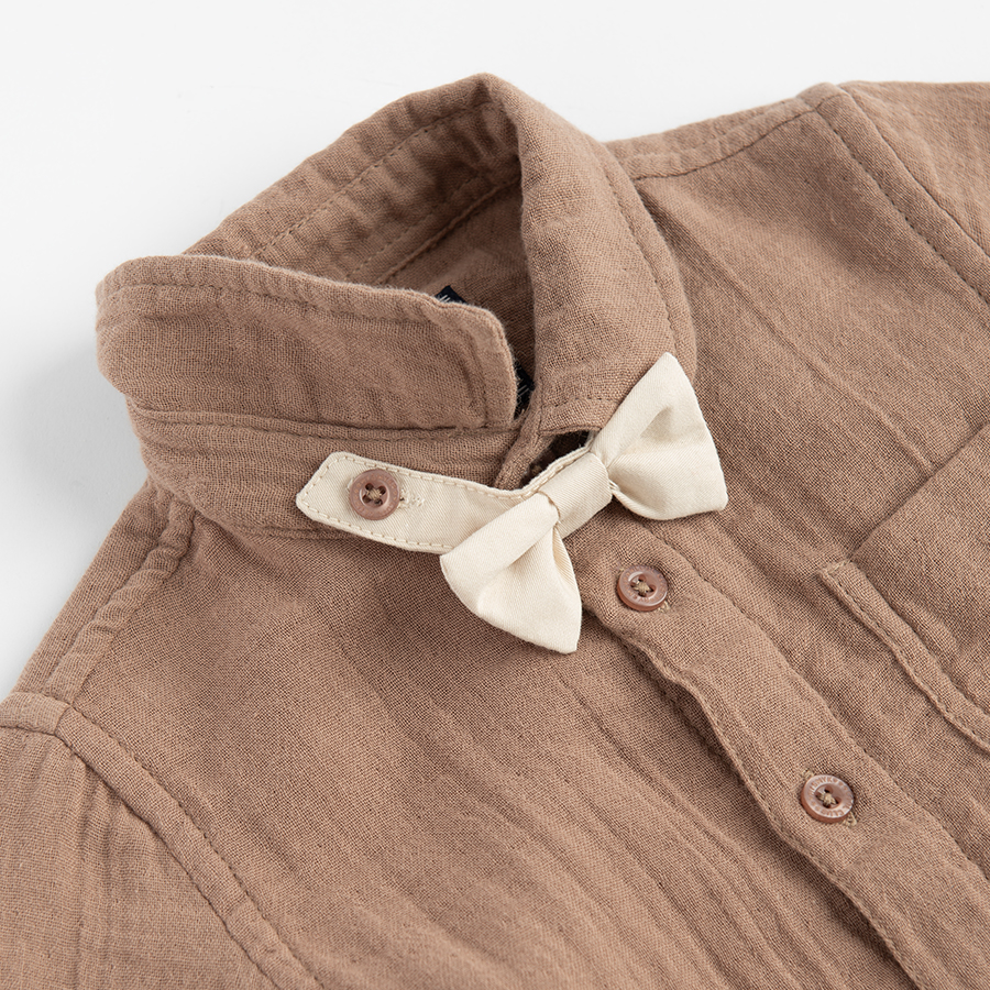 Brown bodysuit with bow tie and ecru pants with suspenders