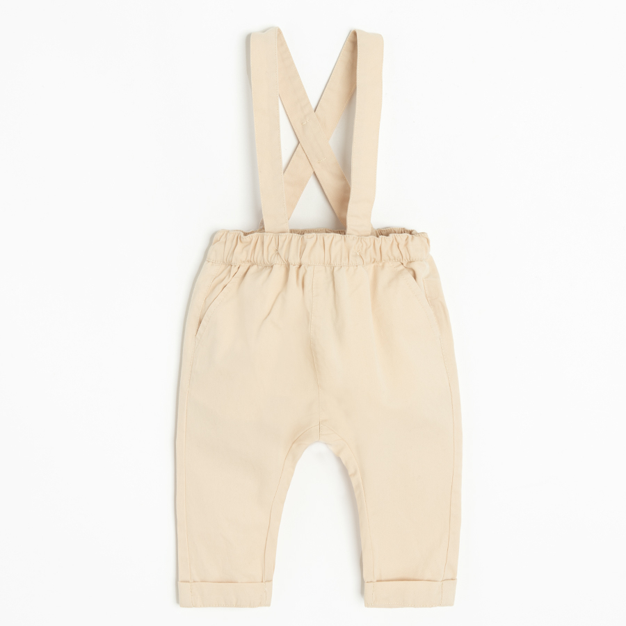 Brown bodysuit with bow tie and ecru pants with suspenders