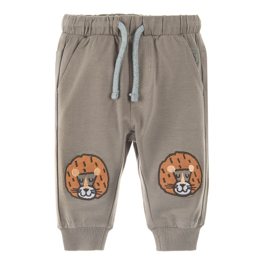 Light borwn jogging pants with lions print on the knees and adjustable waist