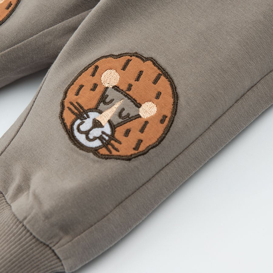 Light borwn jogging pants with lions print on the knees and adjustable waist