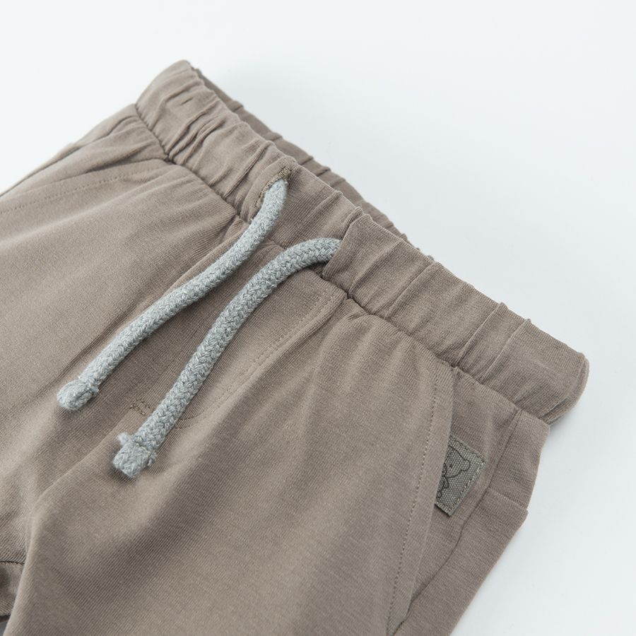 Light borwn jogging pants with lions print on the knees and adjustable waist