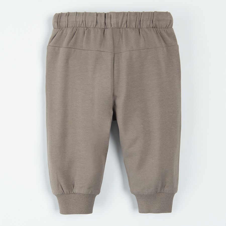 Light borwn jogging pants with lions print on the knees and adjustable waist