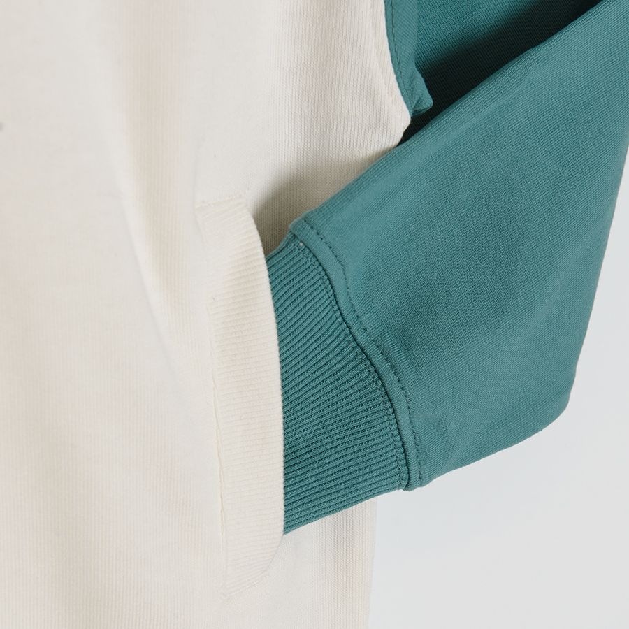 White sweatshirt with a blue and green sleeve