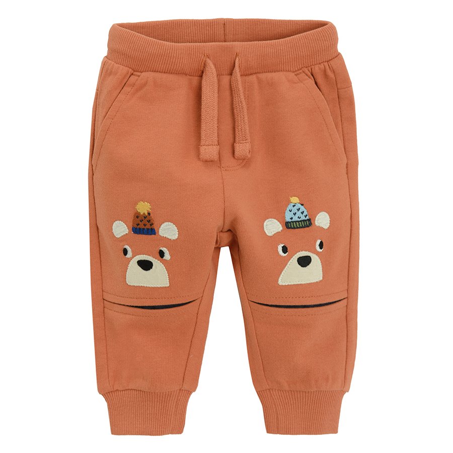 Brown jogging pants with bears print with pom pom caps on the knees