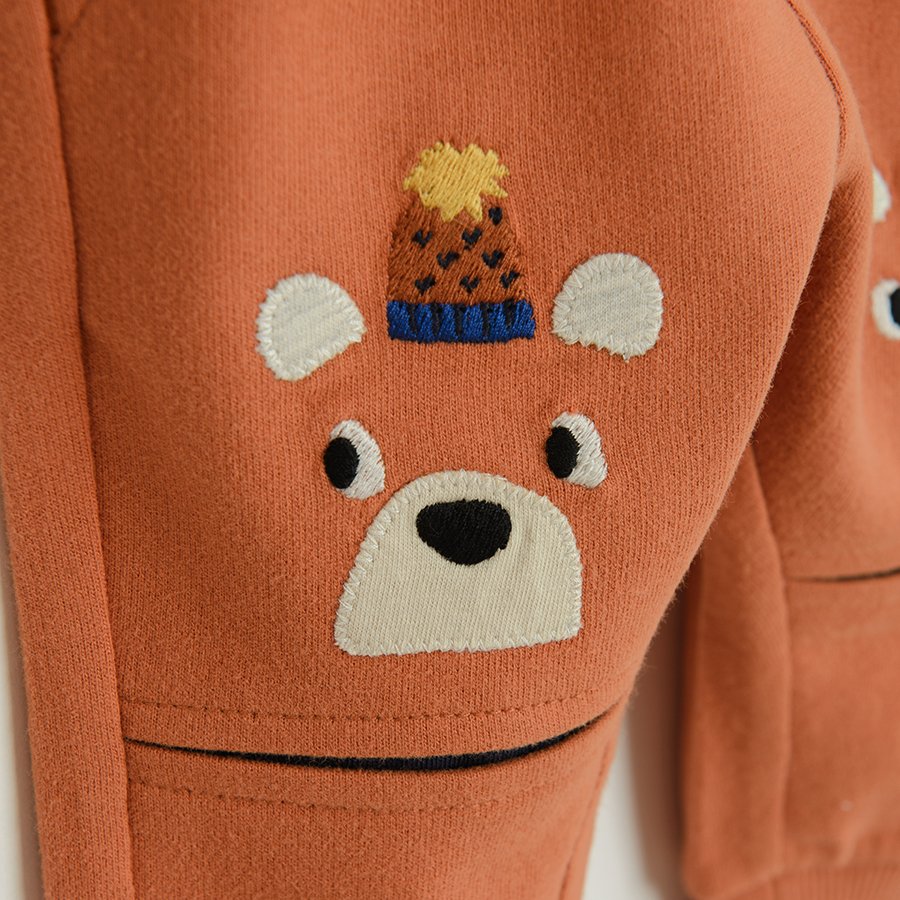 Brown jogging pants with bears print with pom pom caps on the knees