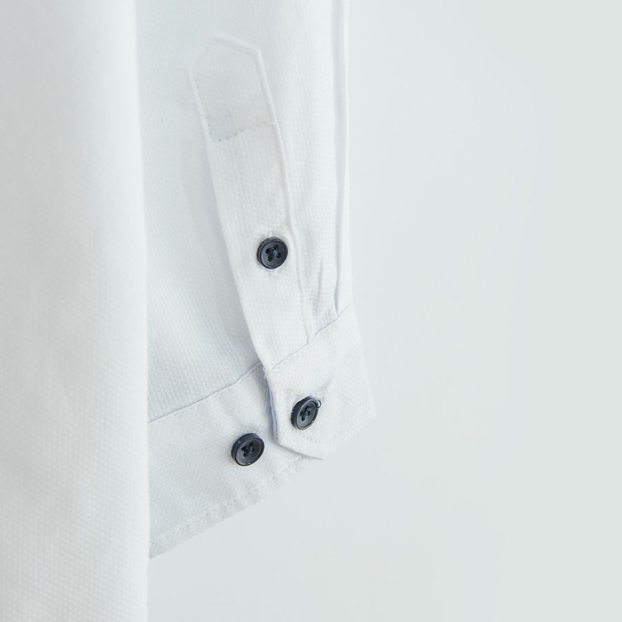 White long sleeve shirt with sleeve rolling up to a button