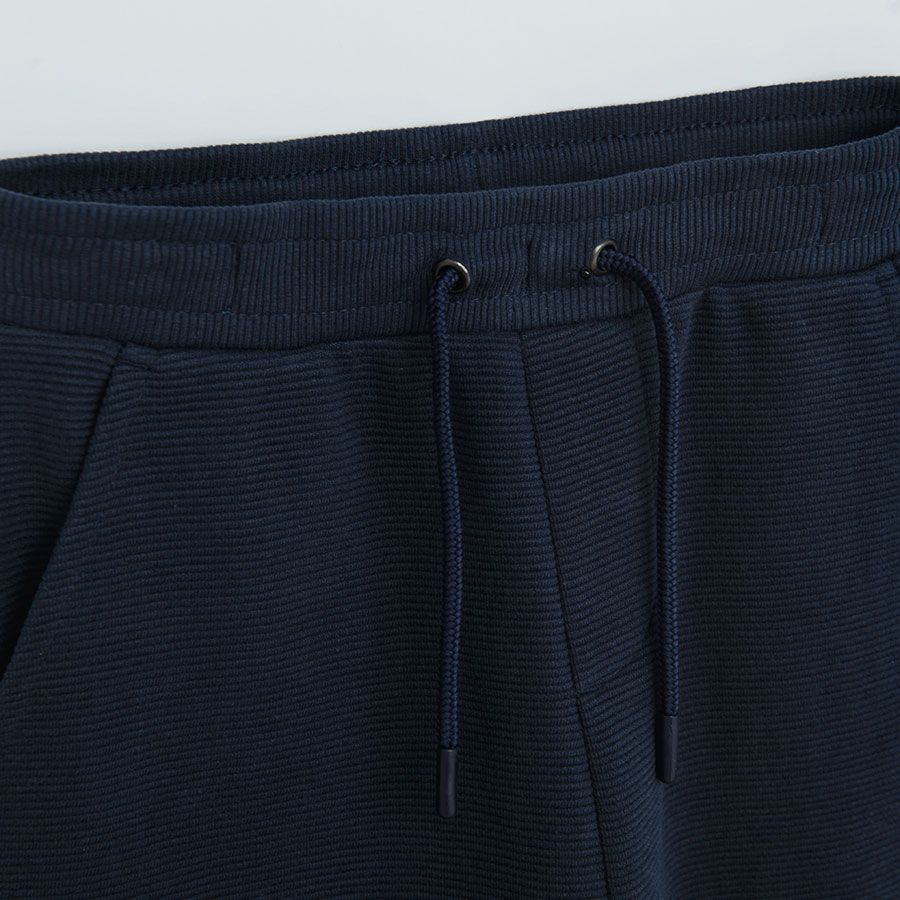 Dark blue jogging pants with cord and elastic around the ankles