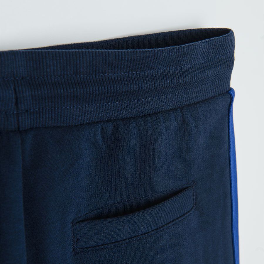 Dark blue jogging pants with yellow, white and blue stripe on the side
