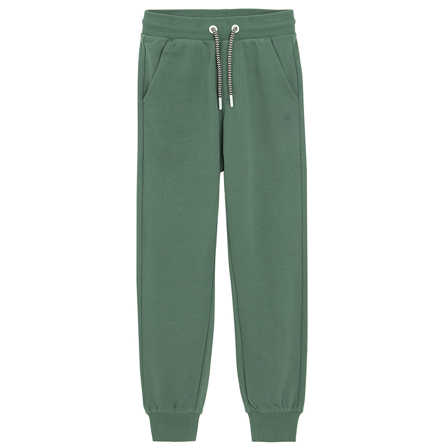 Green sweatpants with elastic around ankles and cord