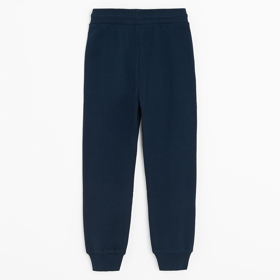 Dark blue sweatpants with elastic around ankles and cord