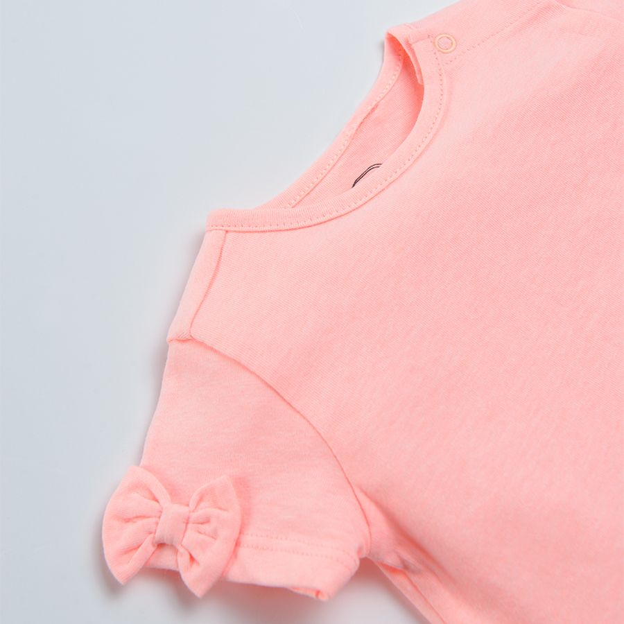 Coral short sleeve blouse with bows on the sleeves and ruffles on the bottom