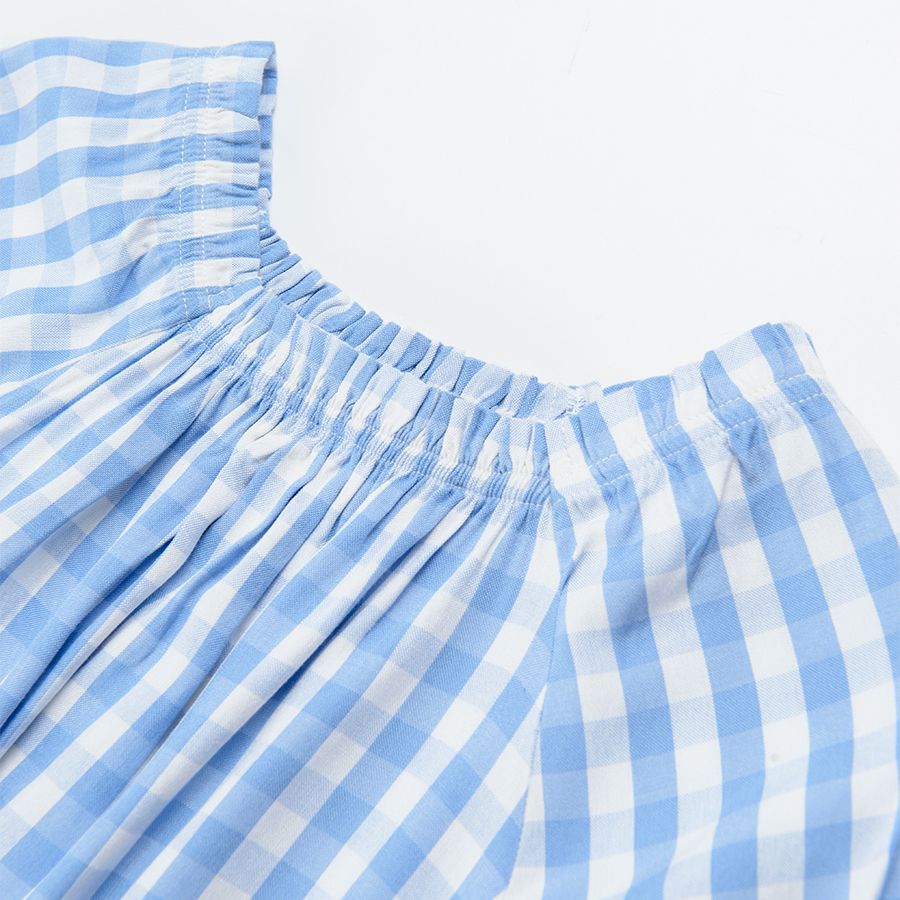 White and blue checked blouse with puffy sleeves and bows on the sleeves