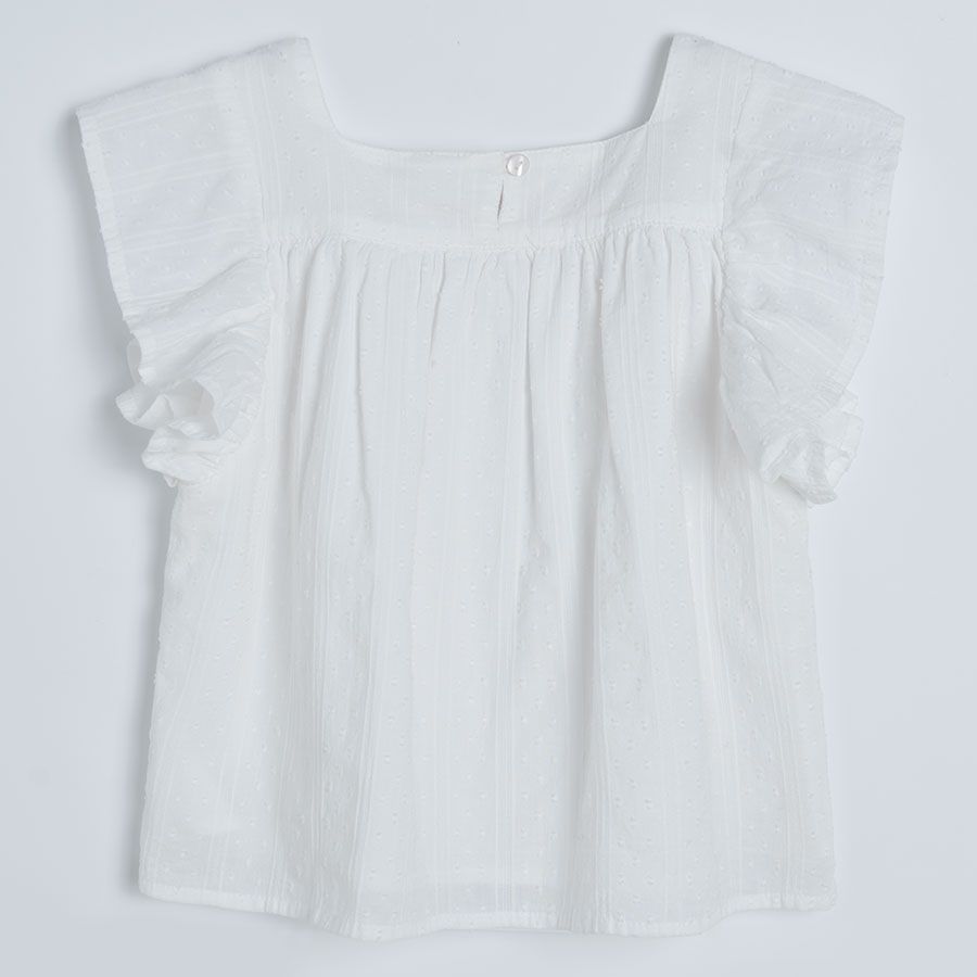 White sleeveless blouse with square embrodered neckline and ruffles on the shoulders