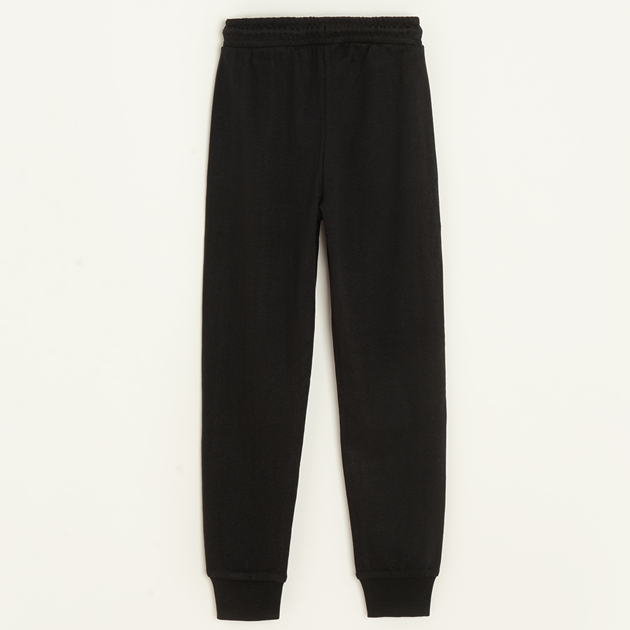 Black sweatpants with elastic on the ankles and cord