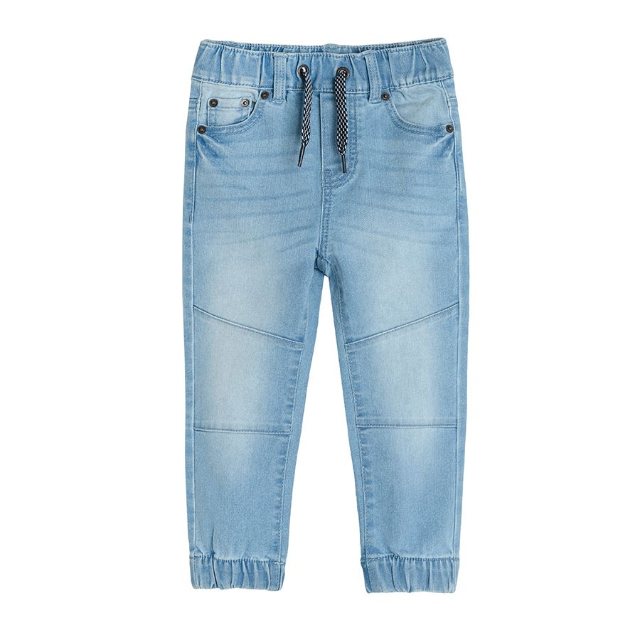 Light blue denim trousers with cord  and elastic band around the ankles